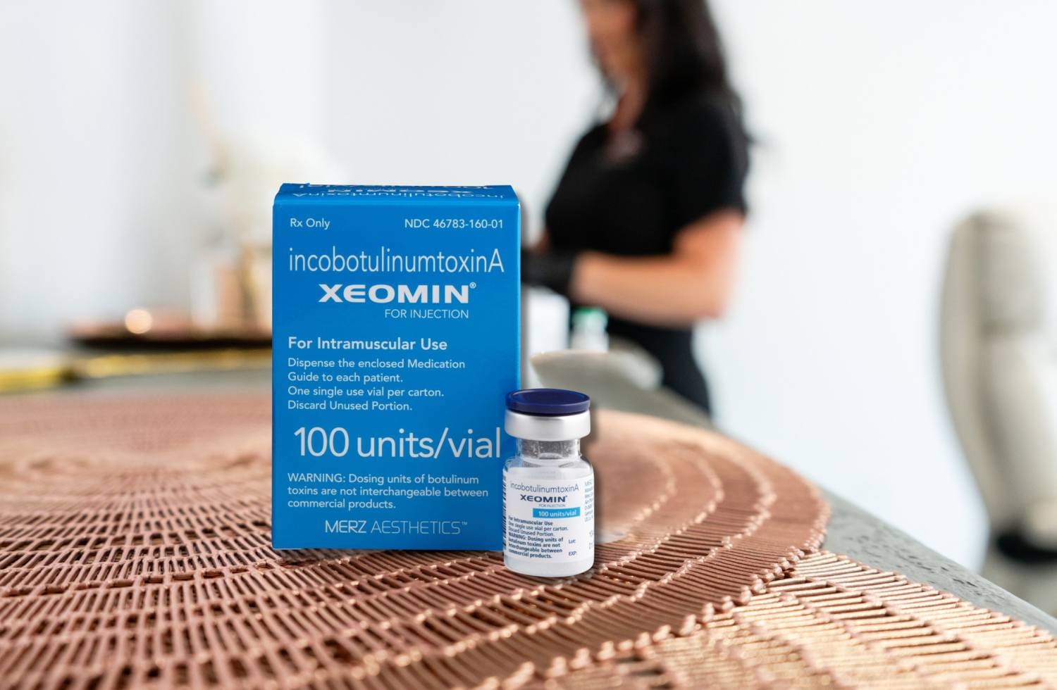 A bottle of medicine sitting next to a woman.