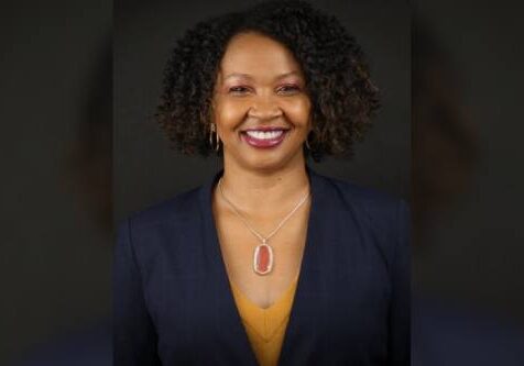 A woman with curly hair and a yellow shirt.