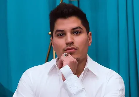 A man in white shirt and tie posing for the camera.